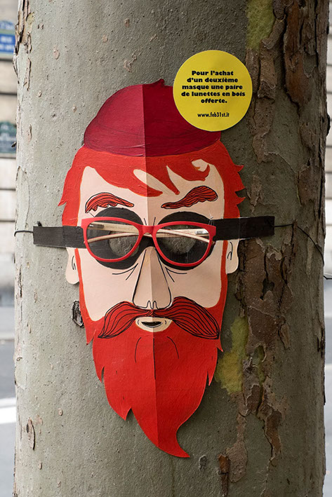 Street marketing avec des masques de bucherons à lunettes attachés sur des tronc d'arbres pour la marque FEB 31 TH par les soeurs siamoises