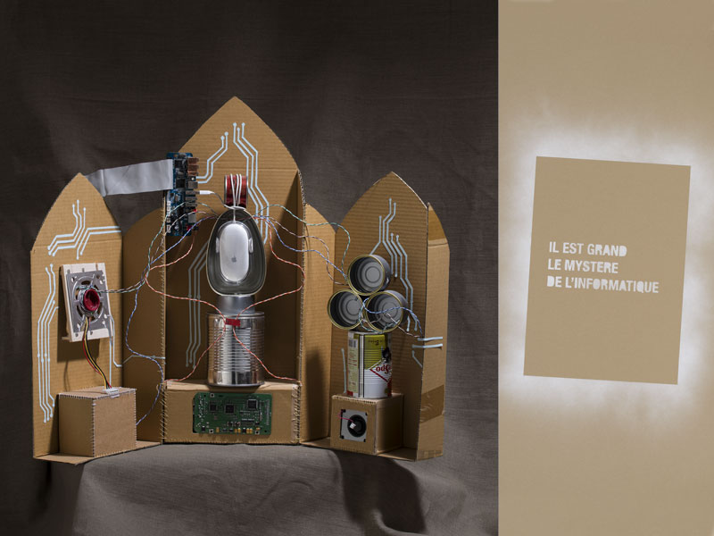 Sur l'autel un triptyque représente le dieu de l'informatiqu à l'aide de boites de conserve, design les soeurs siamoise