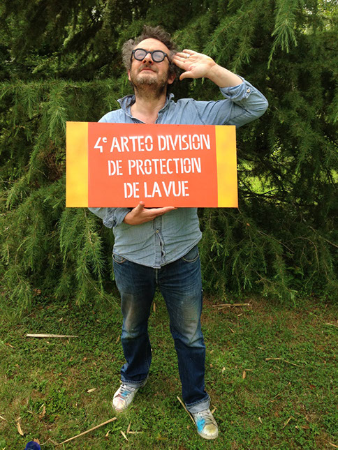 Frédéric Monier la soeur siamoise de Sylvie Massoud qui tient un panneau évoquant l'univers militaire et la zone de combat oculaire. 