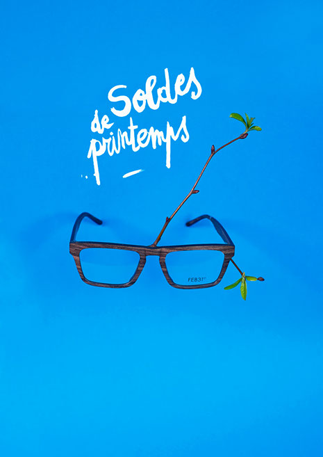 Affiche Artéo pour les soldes de printemps, une paire de lunettes en bois sur lequel pousse une branche d'arbre en bourgeon. 