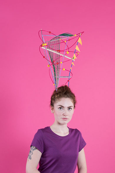 Jeune fille avec un chapeau fait à la main par les soeurs siamoises représentant la reflexion créative.