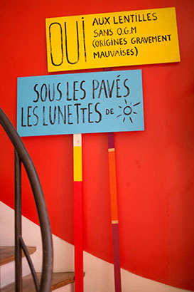 Pancartes de manifestation. Oui aux lentilles sans OGM et sous les pavés les lunettes. Design les soeurs siamoises. 