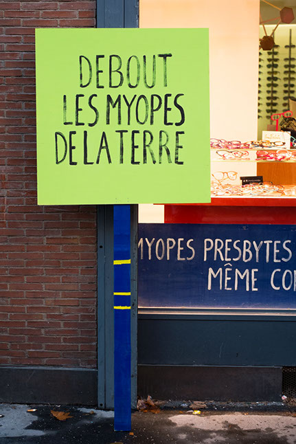 Pancartes de manifestation. Debout les myopes de la terre. Design les soeurs siamoises. 