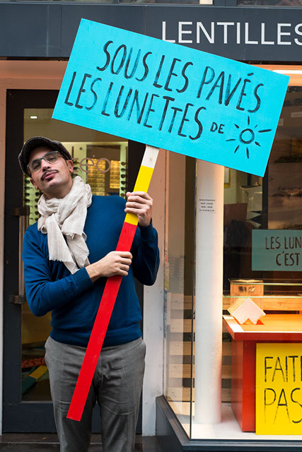 Pancarte de manifestation. Sous les pavés les lunettes de soleil. Design les soeurs siamoises. 
