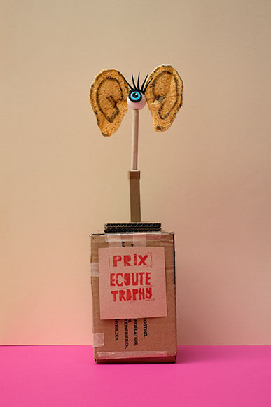 Trophées avec un texte Prix écoute Trophy, une paire d'oreille en éponge est fixée sur un socle. Design les soeurs siamoises.